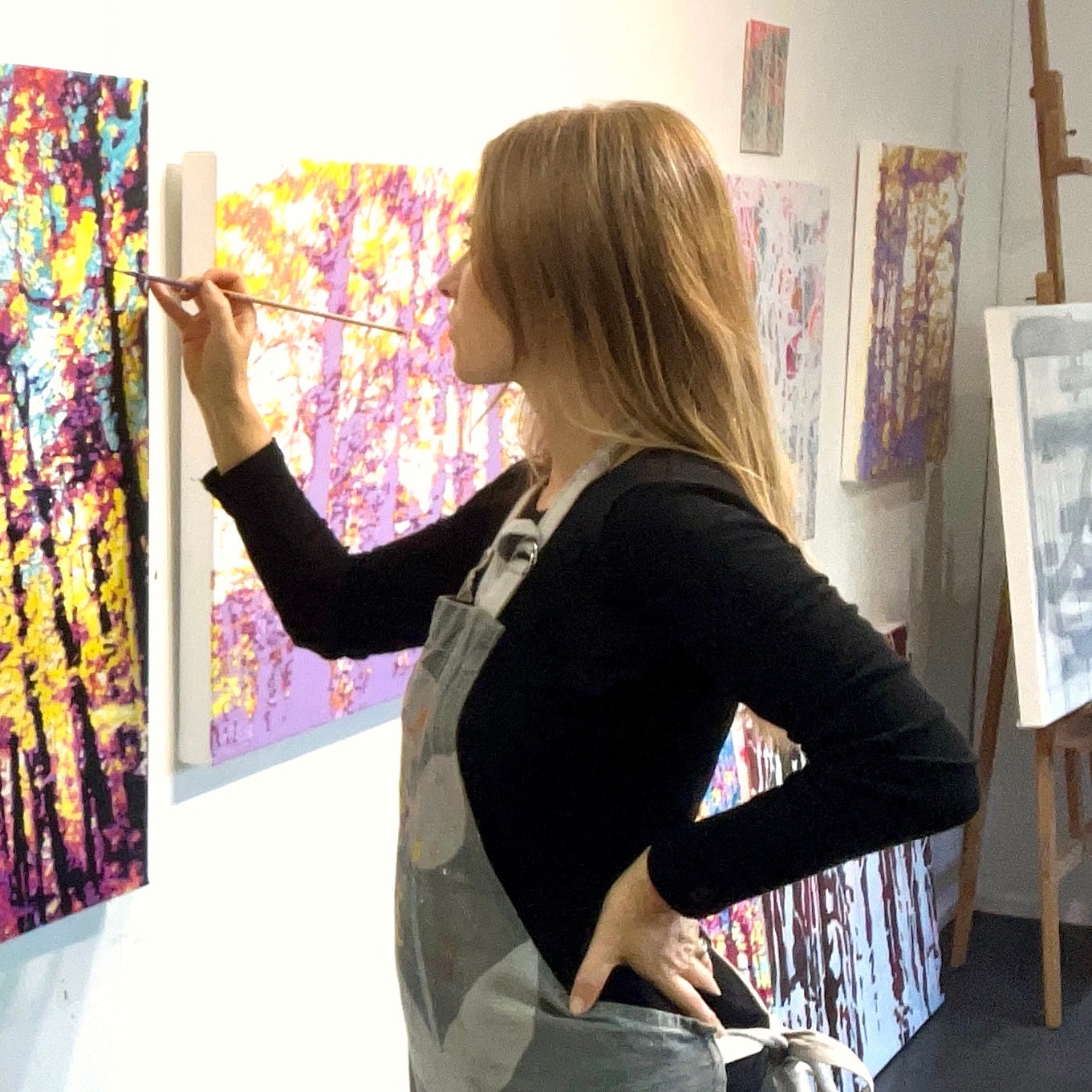 Alex DiMercurio in her studio painting Hey Sunshine