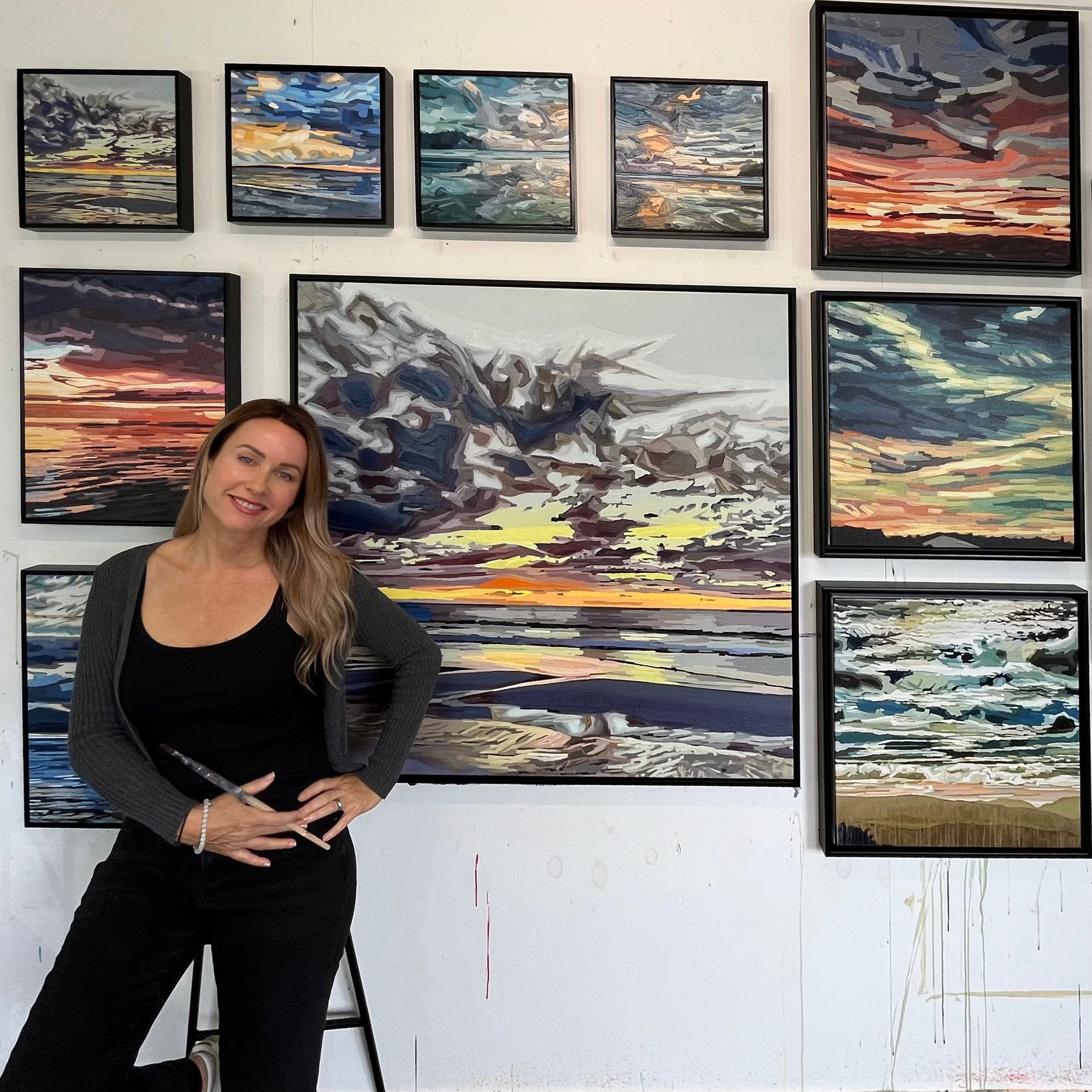 New Zealand artist Alex DiMercurio surrounded by her original cloud and seascape paintings in her Wellington studio