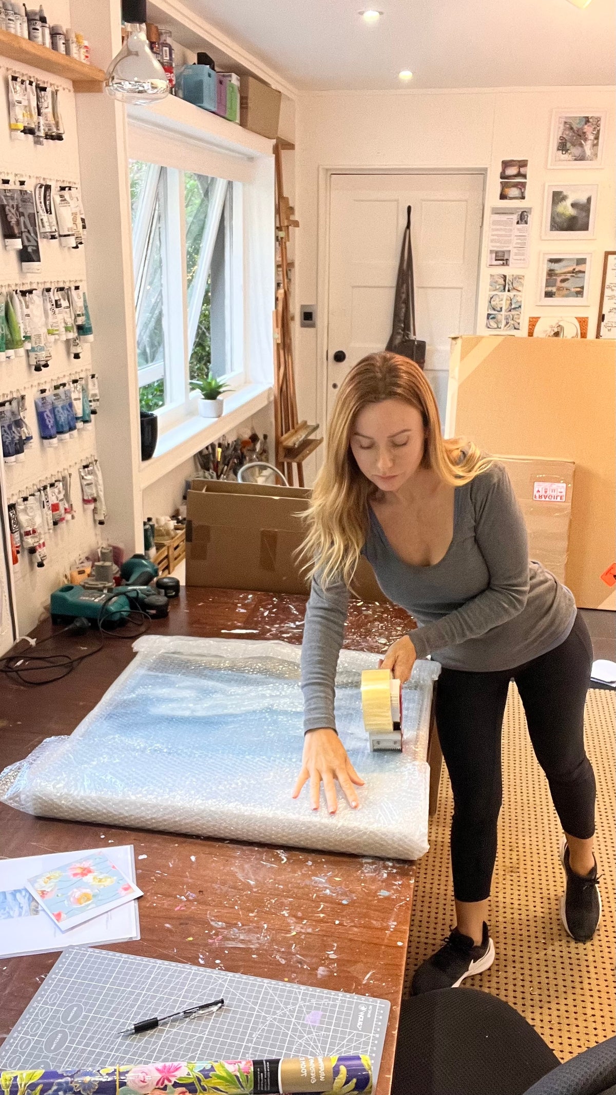 Artist Alex DiMercurio carefully packing an original painting for delivery from her Wellington studio to send to a collector